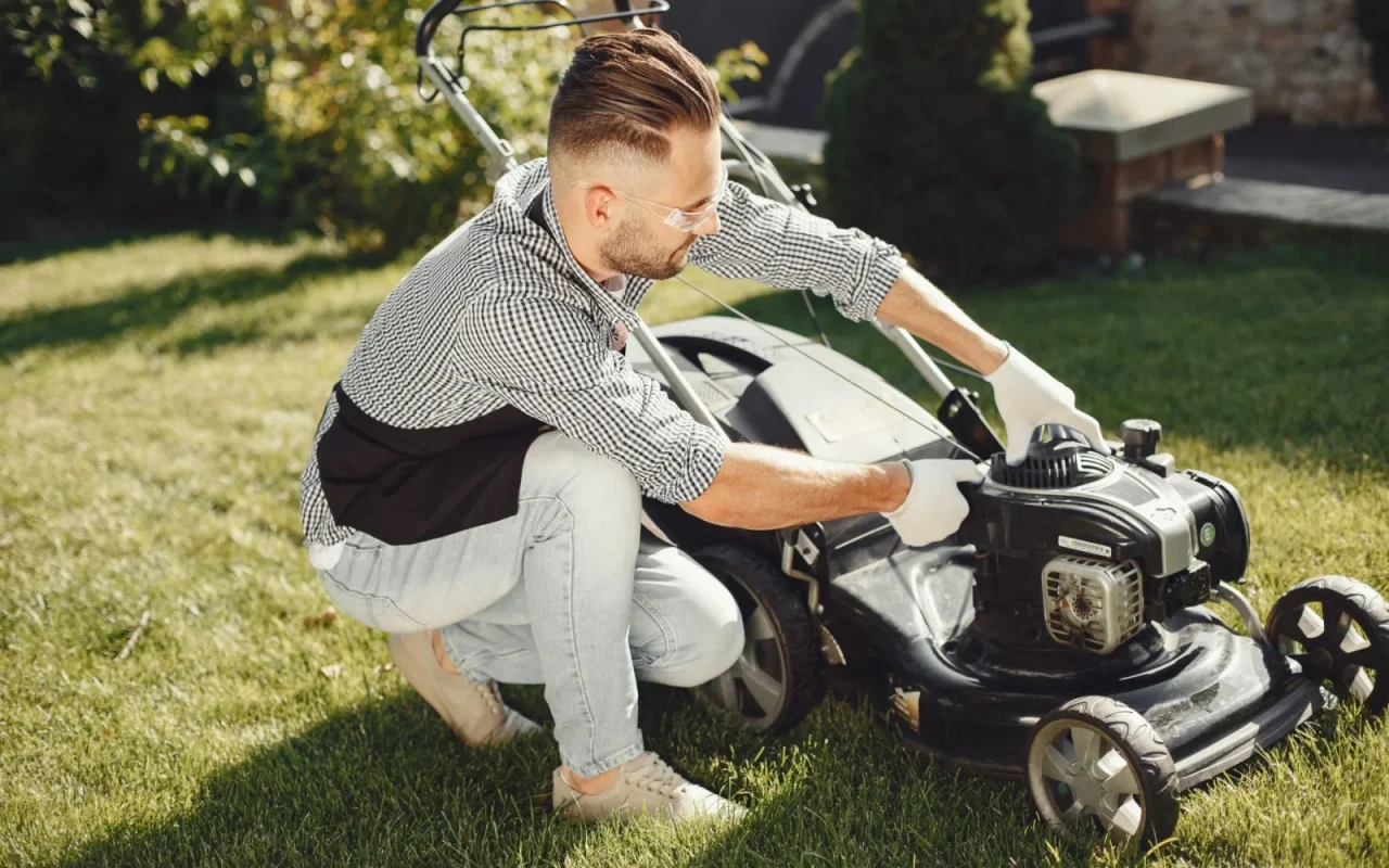 A robot lawn mower moving across a healthy green lawn beside a suburban home