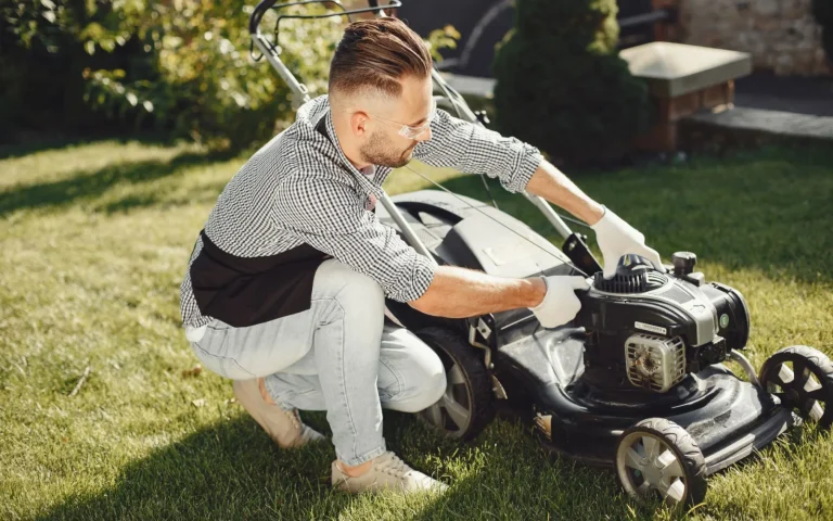 A robot lawn mower moving across a healthy green lawn beside a suburban home