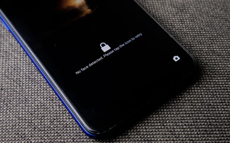 Phone showing a security lock screen next to a robot mower on grass