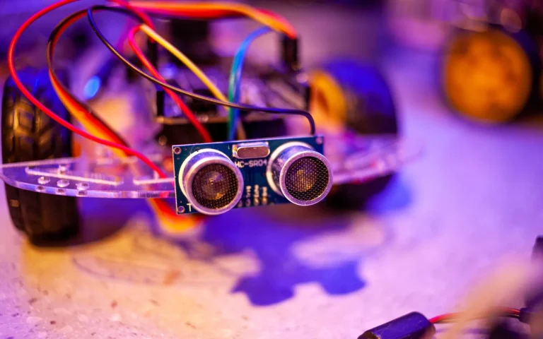 Close-up of a robot mower showing its front camera sensor on green grass