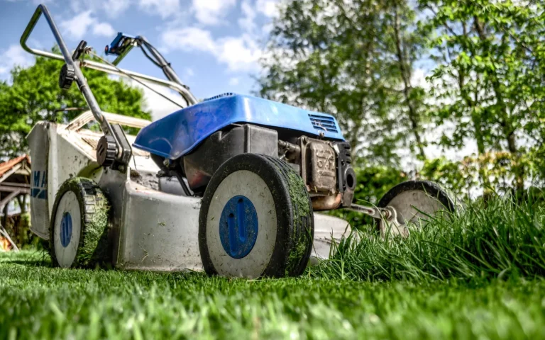 Hands in gloves fitting a new razor blade onto the underside of a robot lawn mower
