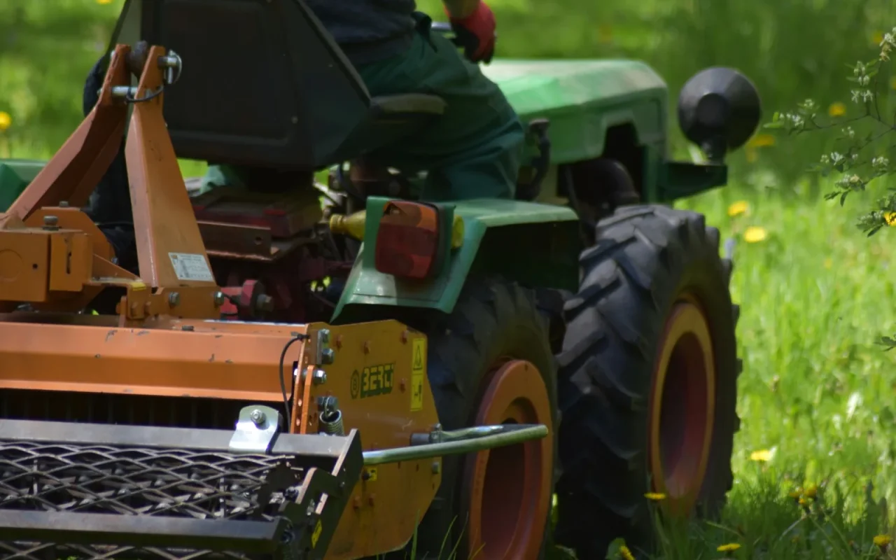 A robot lawn mower stuck at the edge of a green lawn illustrating a common buying mistake