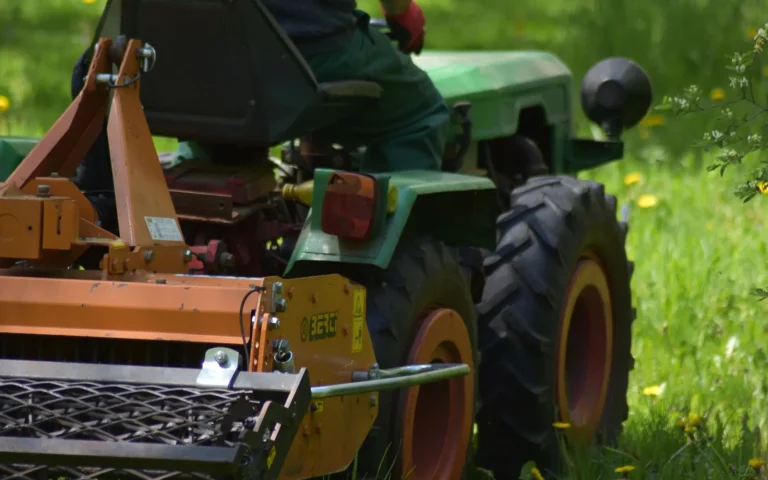 A robot lawn mower stuck at the edge of a green lawn illustrating a common buying mistake