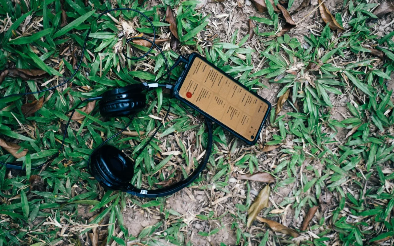 Homeowner adjusting a robot mower schedule on a phone app beside a green lawn