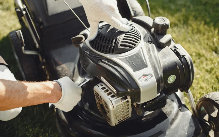 Robot mower beside a lawn with repair tools and a printed checklist on a bench