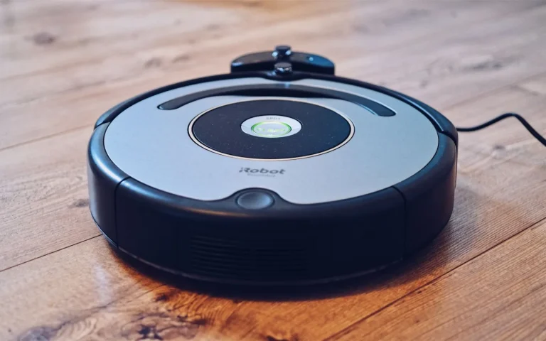 A robot lawn mower on grass and a robot vacuum indoors shown side by side