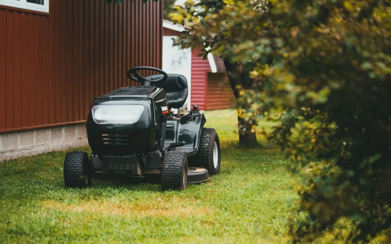 Used robot lawn mower sitting on green grass ready for inspection before purchase