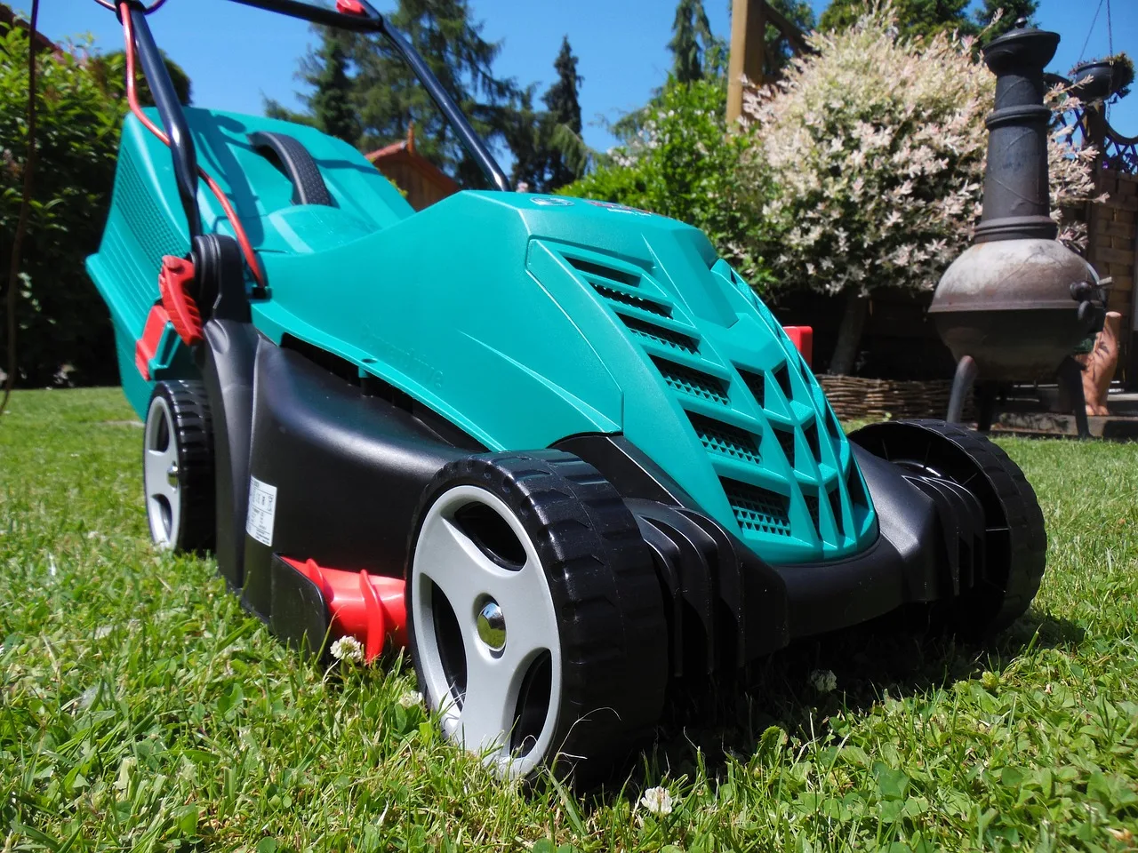 Robot mower steering around a garden hose and toy on a family lawn