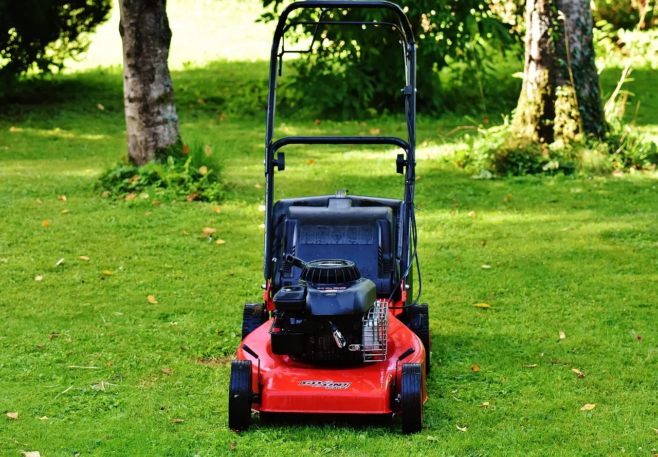 Robot mower crossing a neat green lawn on a sunny afternoon