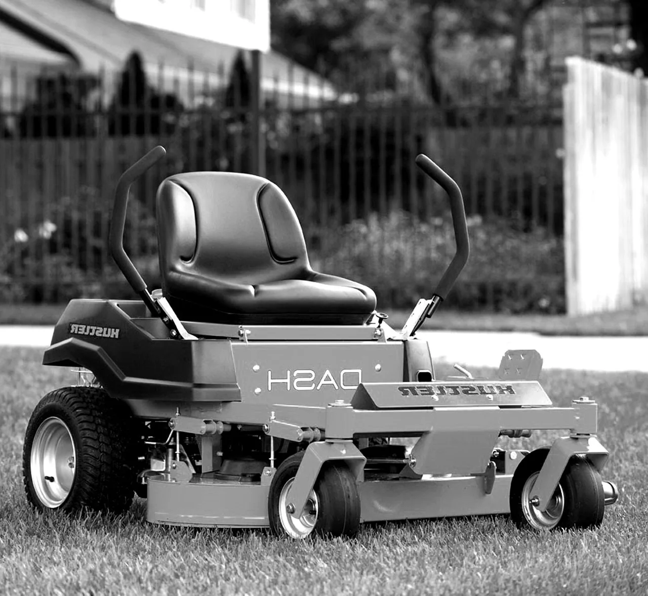 Plastic scraper removing packed grass from the underside deck of a robot mower