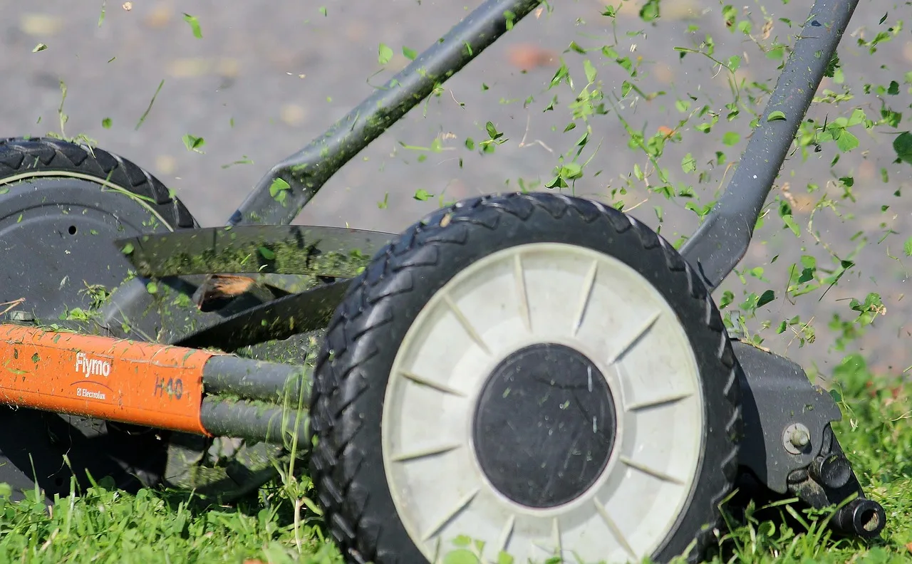 Underside of a robot lawn mower showing the cutting blade disc and clippings