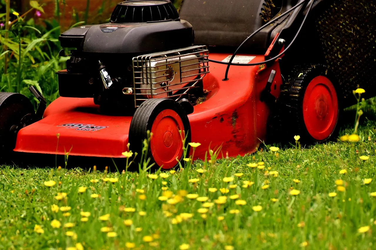 Close view of a robot mower drive wheel with grass wrapped around the axle