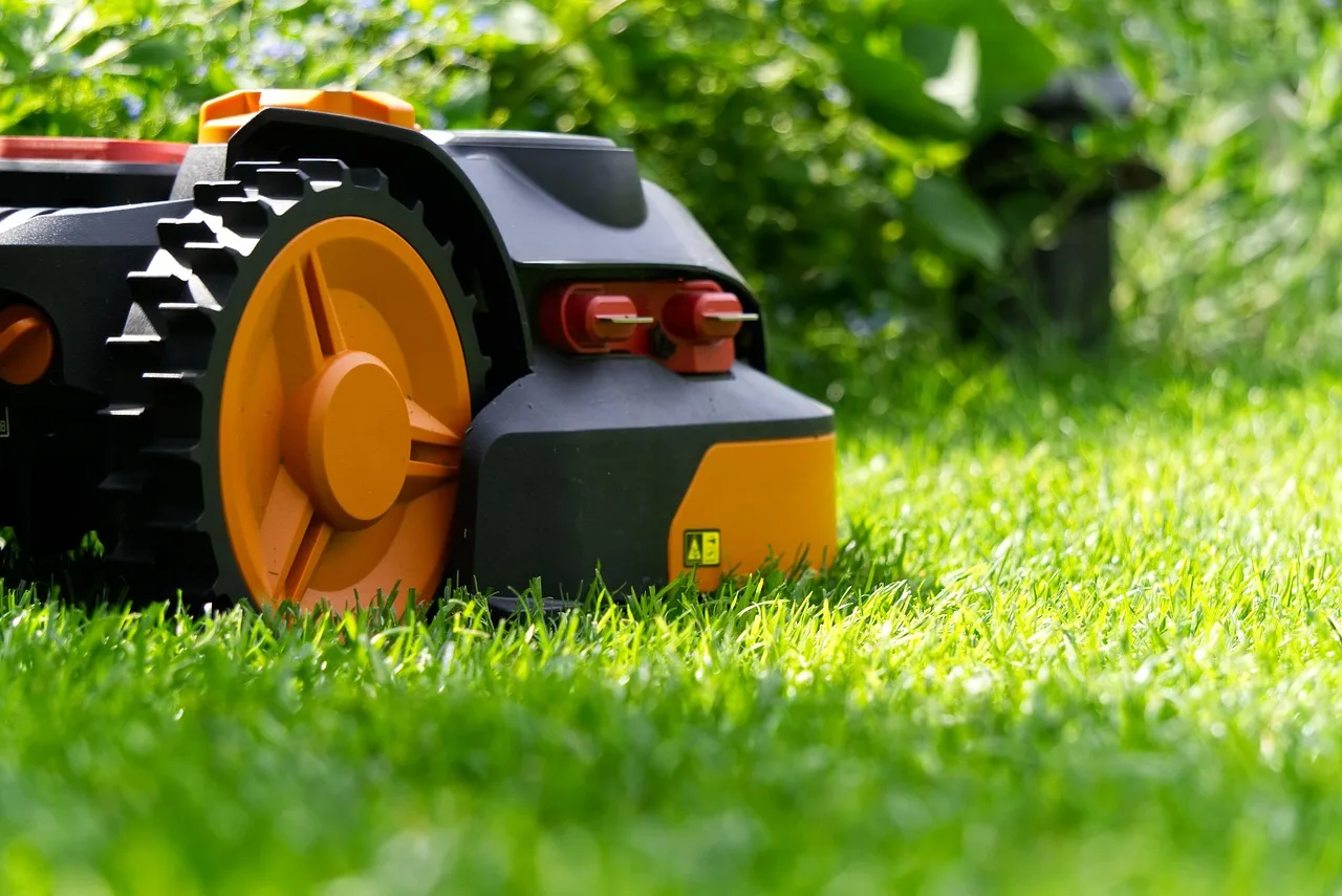 Close up of a robot mower front sensor array against a green lawn backdrop