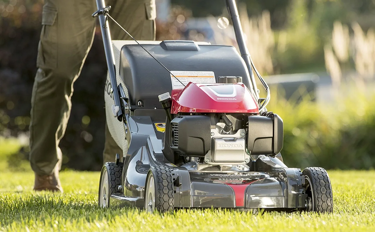 Robot mower sitting on its charging dock in spring sunshine after winter storage