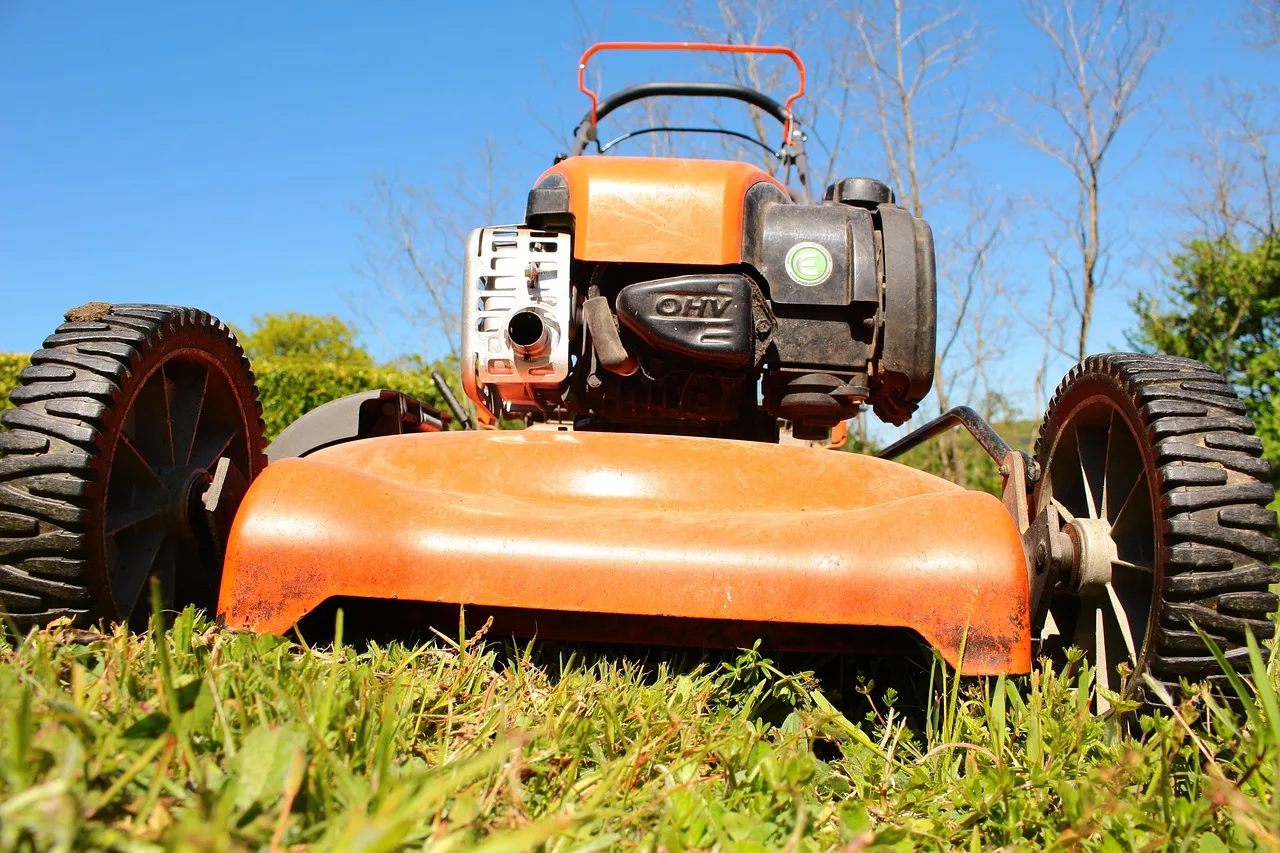 Robot mower halted on a lawn with tall grass partly cut around it