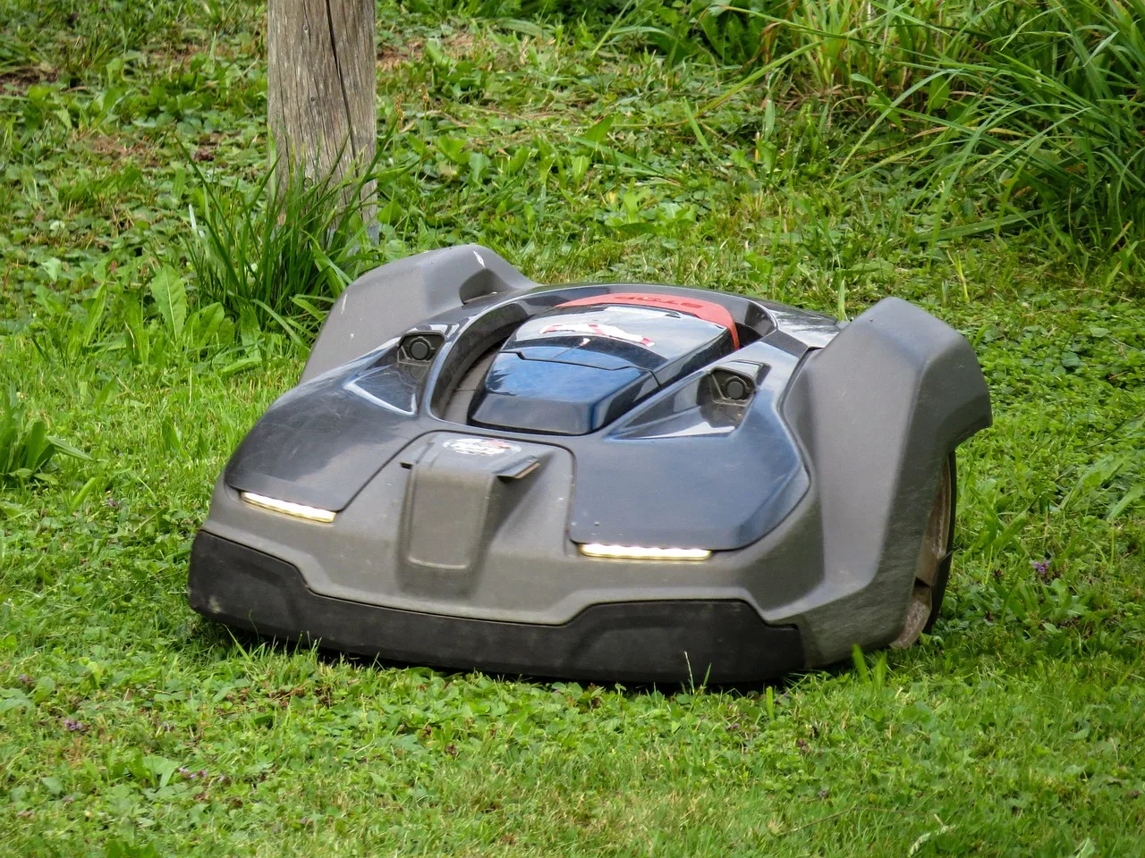 A professional lawn crew mowing and edging a residential green lawn