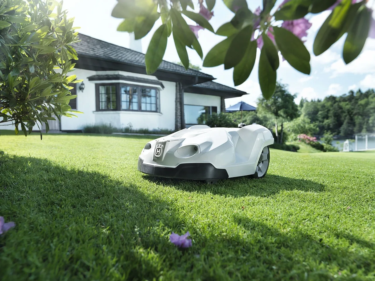 A robot mower quietly cutting grass on a neat suburban lawn