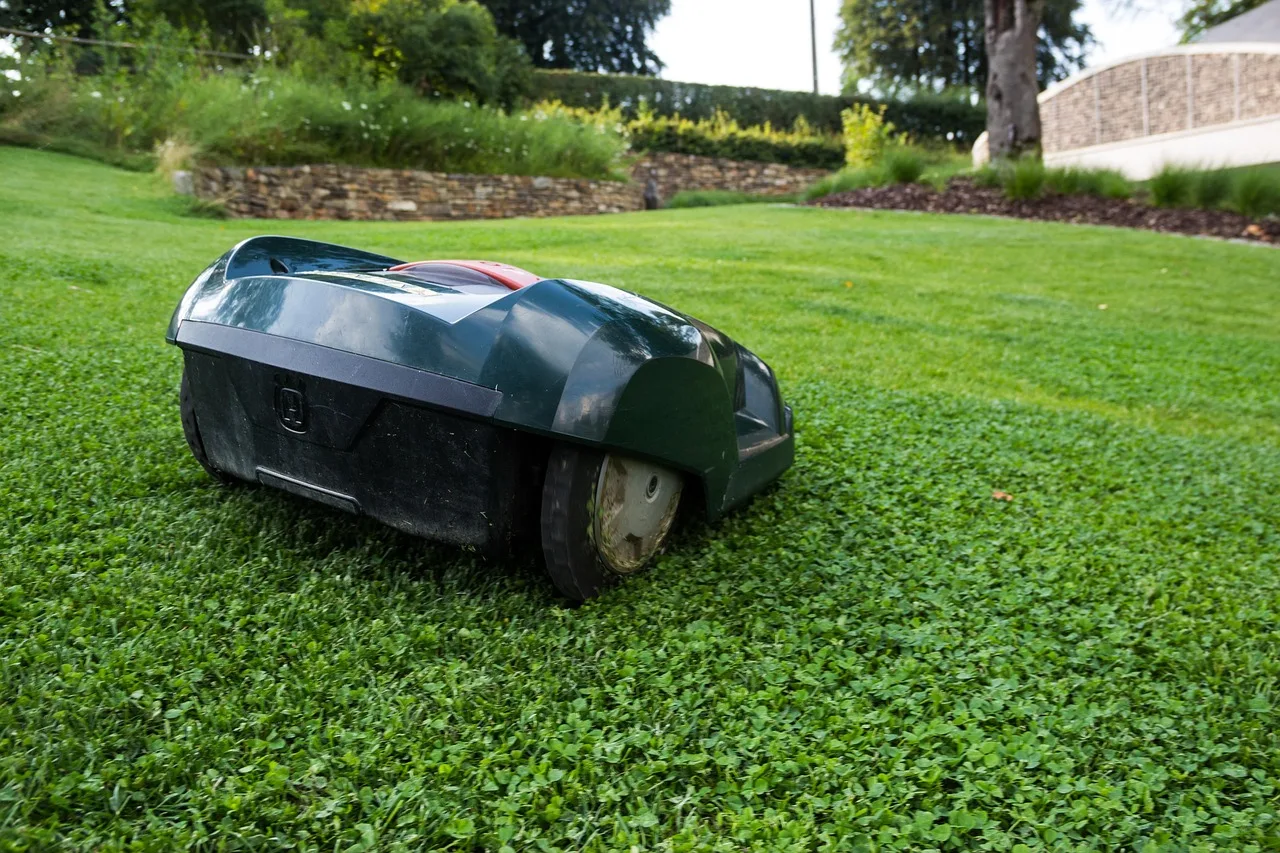 A robot lawn mower cutting a neat green lawn on a sunny day