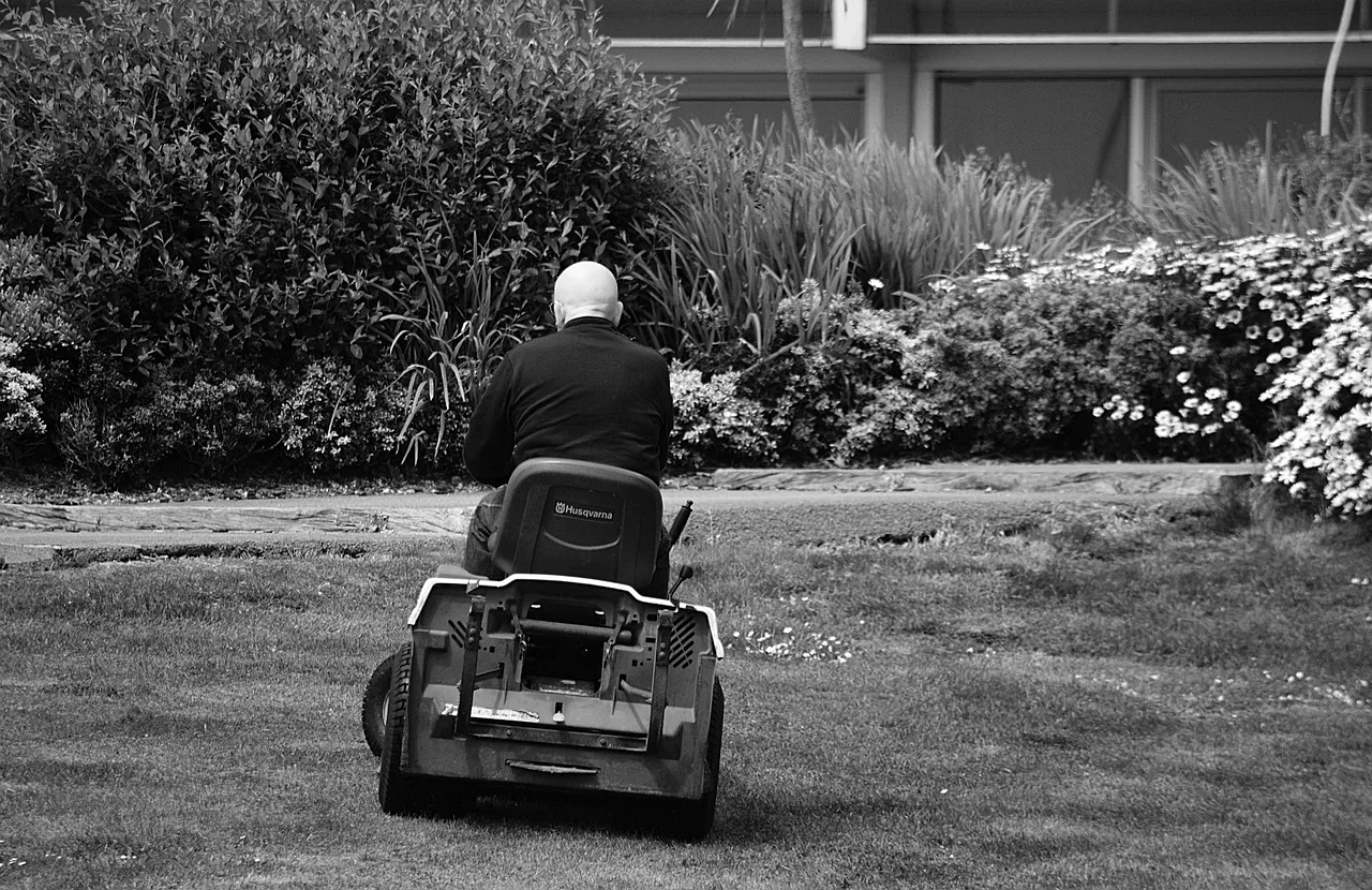 Robot mower returning to its charging dock at the edge of a lawn